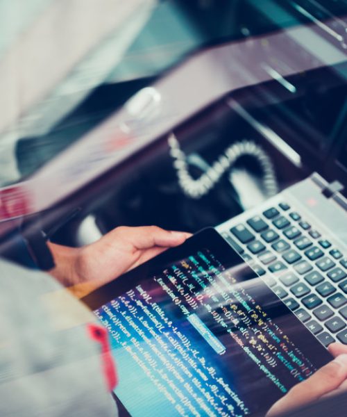 Hacker using computer, smartphone and coding to steal password and private data remotely from car