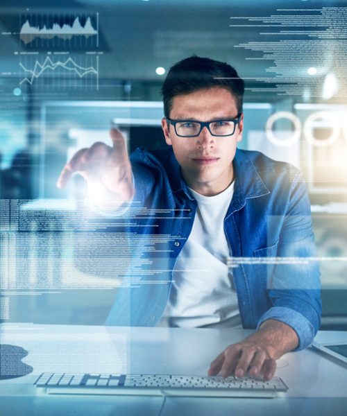 Portrait of a focused young programmer working on his computer in the office during the night.